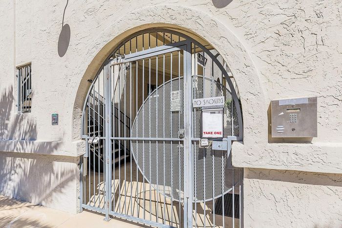 Charming gated entrance with ornate arch design, evoking a sense of secure and stylish living.