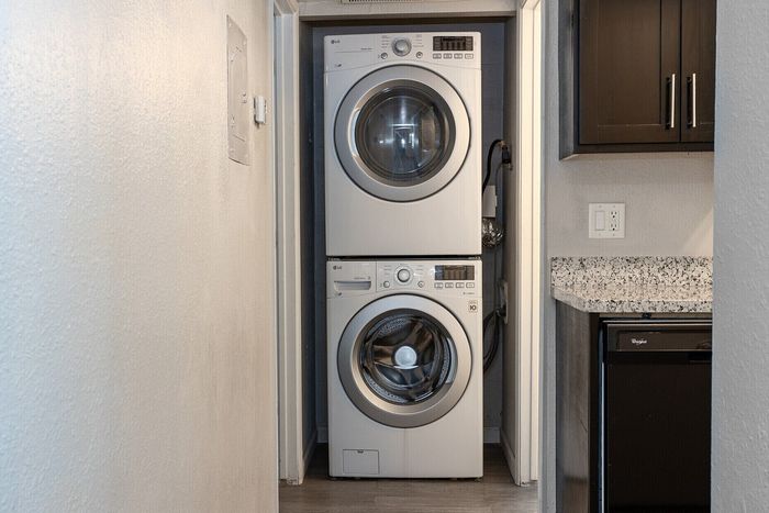 Convenient in-unit laundry with sleek stacked washer and dryer, nestled in a modern apartment hallway.