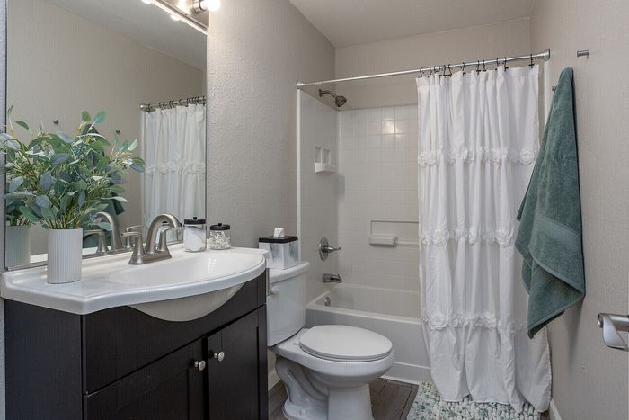 Elegant bathroom with modern fixtures, sleek vanity, and inviting shower, enhanced by fresh greenery for a spa-like feel.