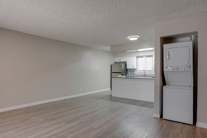 Modern open-plan apartment with sleek kitchen, cozy corner laundry, and contemporary flooring.