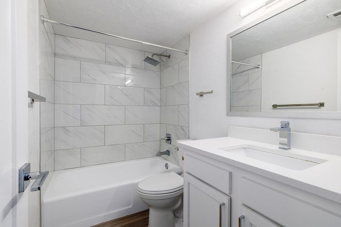 Sleek and modern bathroom with elegant marble tiles, spacious vanity, and a luxurious rainfall shower.