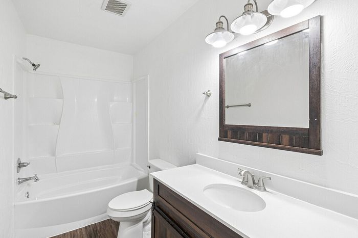 Bright and elegant bathroom featuring modern fixtures, a sleek vanity, and a spacious bathtub with a shower.