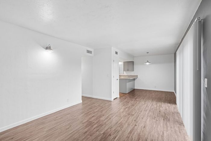 Bright and modern open-concept living area with elegant hardwood flooring and a stylish kitchen counter.