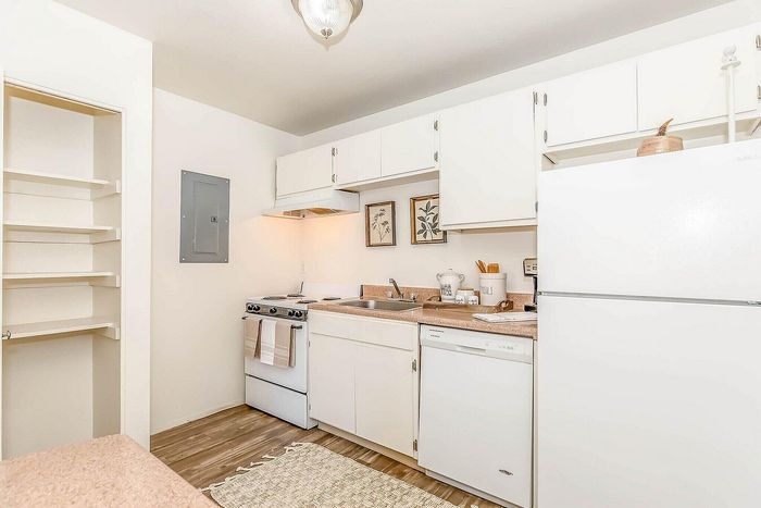 Bright, inviting kitchen featuring sleek white cabinets, modern appliances, and warm wood flooring; perfect for culinary creativity.