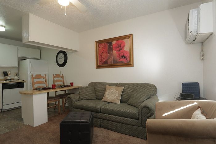 Cozy living space with a stylish couch, charming dining nook, and modern kitchen design.