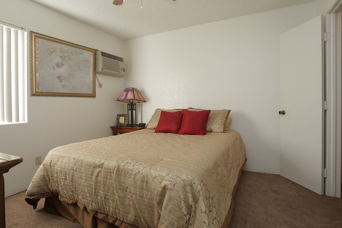 Cozy bedroom with stylish decor, featuring a comfortable bed with elegant bedding, framed art, and a warm, inviting atmosphere.