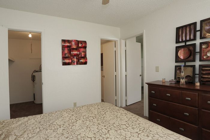 Inviting bedroom with stylish decor, featuring a cozy bed, chic wall art, and ample closet space.