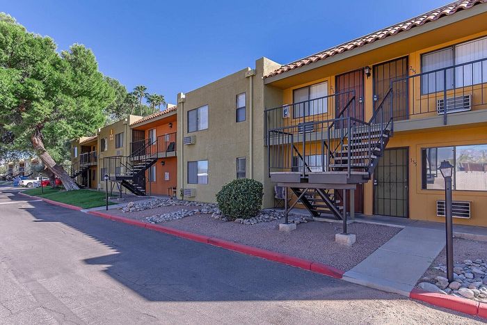 Charming apartment complex with colorful facades and lush greenery, offering inviting stairways and serene outdoor spaces.