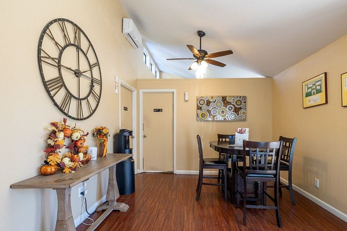 Inviting dining area featuring elegant decor, a large rustic clock, and warm wooden flooring.