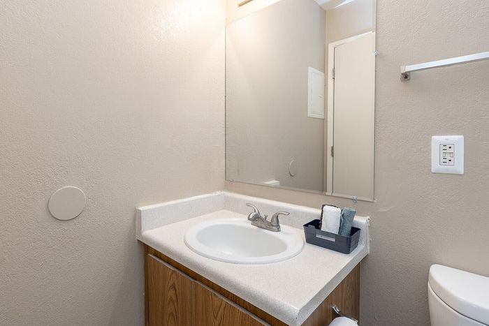 Charming bathroom with modern fixtures, sleek vanity, and large mirror, perfect for daily routines.