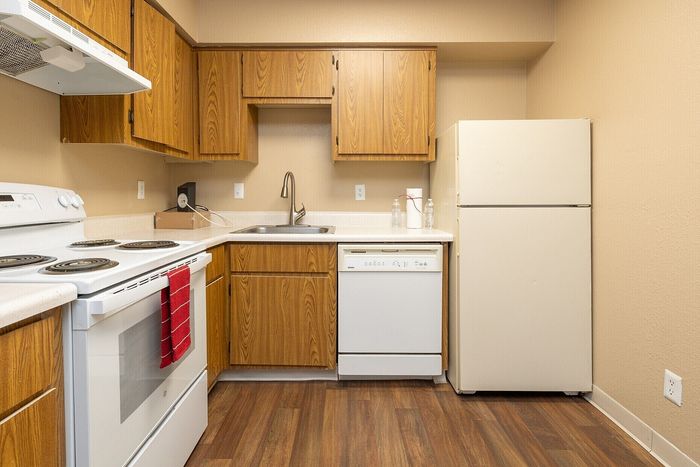 Cozy kitchen featuring wood cabinetry, modern appliances, and durable flooring, perfect for culinary creativity.