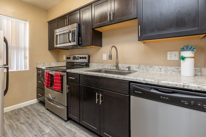Chic kitchen design with sleek dark cabinetry, modern stainless steel appliances, and elegant granite countertops.