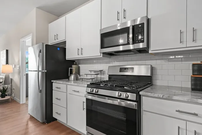 Modern kitchen with sleek stainless steel appliances, elegant white cabinetry, and stylish subway tile backsplash.