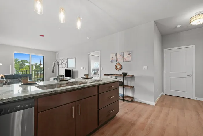 Modern open-concept kitchen and living area with sleek countertops, ample natural light, and contemporary furnishings.