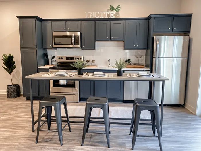 Stainless steel appliances, modern design table & chairs in kitchen at Incite at Troy | Downtown Troy Apartments