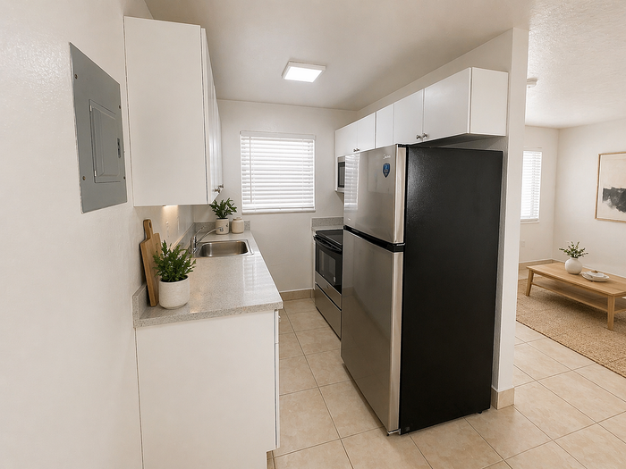 Modern kitchen with sleek stainless-steel appliances, bright cabinetry, and an inviting open-concept design leading to a cozy living area.