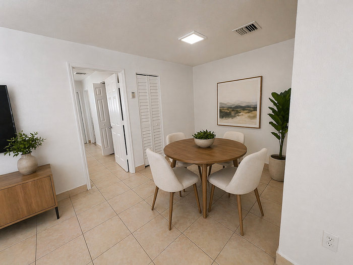 Elegant dining area with round wooden table, modern chairs, and tasteful decor in a bright, cozy apartment.