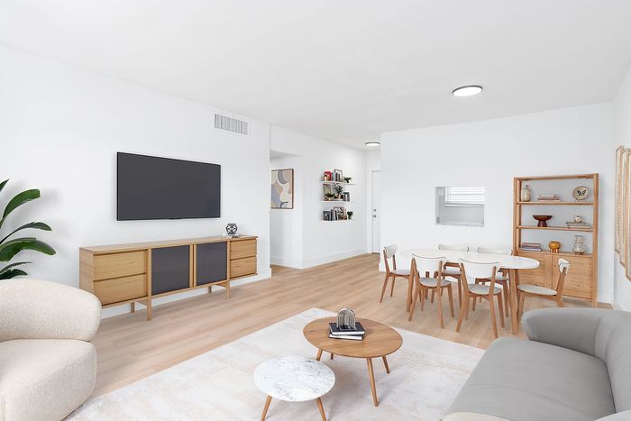 Modern living and dining area with sleek decor, featuring a stylish entertainment center, cozy sofa, and elegant dining set.