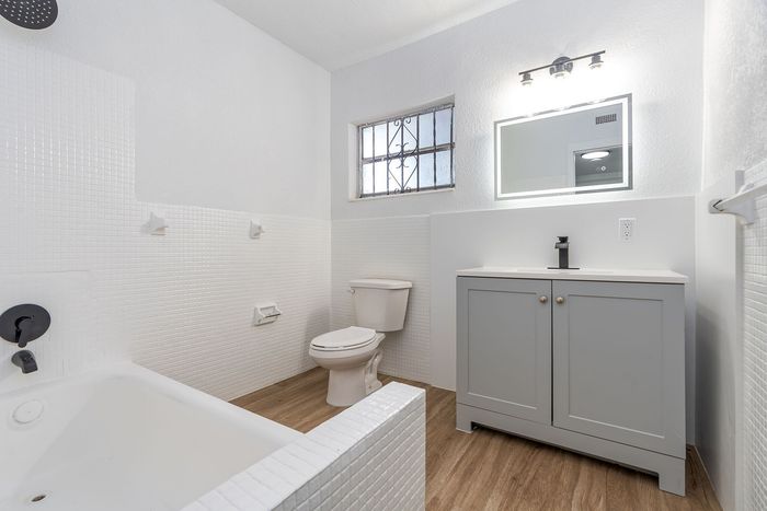 Chic bathroom with elegant white tiles, modern vanity, and bright lighting creating a welcoming ambiance.