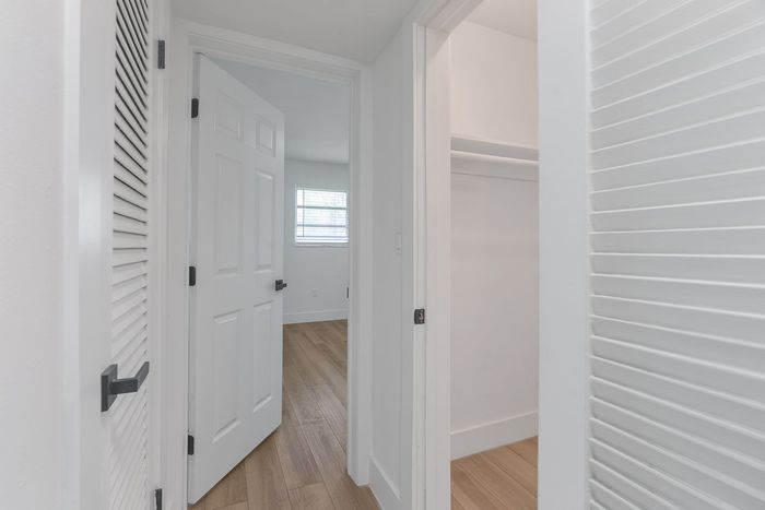 Bright and inviting hallway with stylish hardwood floors and ample closet space.