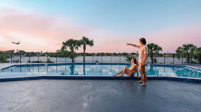 Breathtaking waterfront pool area with a serene lake view at sunset, featuring a relaxing atmosphere for residents.