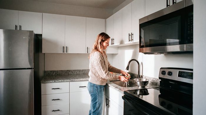 Modern kitchen with sleek stainless steel appliances, chic granite countertops, and ample white cabinetry, offering a stylish and functional cooking space.