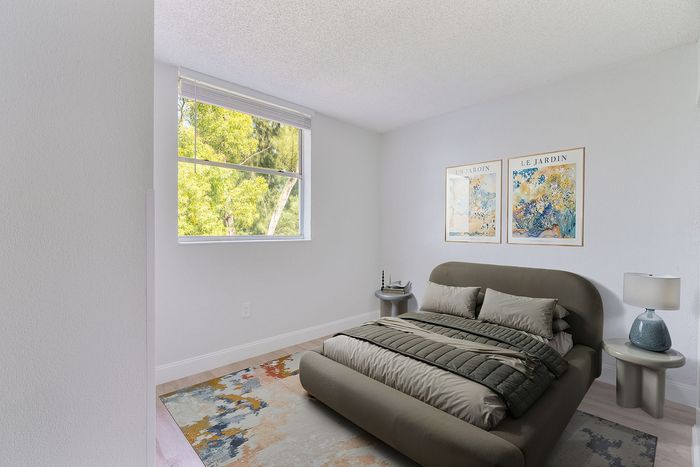 Bright and airy bedroom featuring a modern bed, abstract art, and large window with a scenic view.