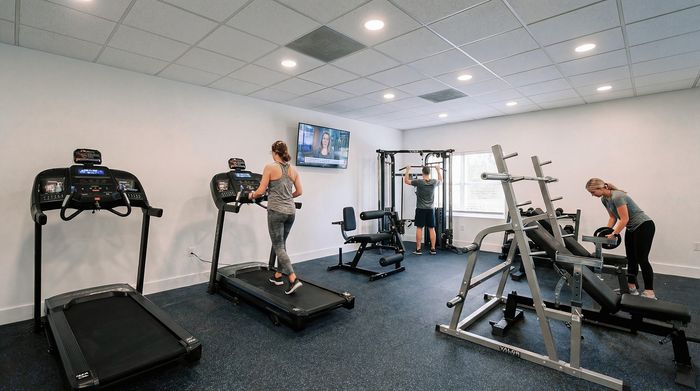 Modern fitness center with state-of-the-art equipment and spacious workout area, featuring treadmills, weight machines, and a vibrant atmosphere.