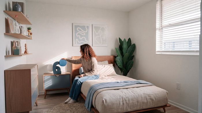 Chic bedroom featuring modern decor with abstract art, wooden furniture, and a cozy ambiance.