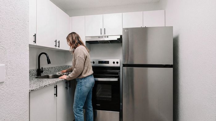 Modern kitchen with sleek stainless steel appliances, white cabinetry, and granite countertops, featuring a convenient layout ideal for cooking enthusiasts.