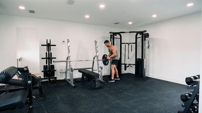 Modern fitness room with state-of-the-art equipment, including a weight bench, weight rack, and multifunctional exercise machine. Ideal for an active lifestyle.