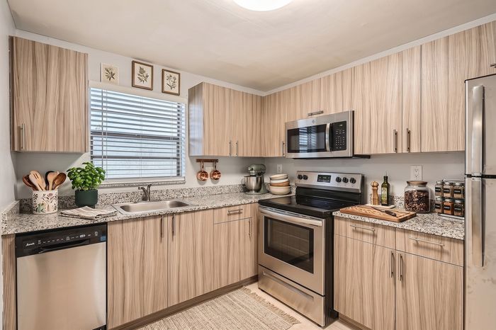 Modern kitchen with sleek wood cabinetry, stainless steel appliances, and granite countertops, ideal for culinary enthusiasts.