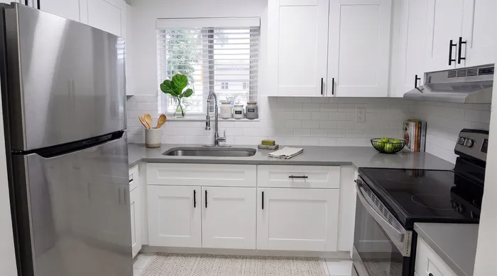 Contemporary kitchen with sleek white cabinetry, stainless steel appliances, and a modern sink area, offering a bright and inviting culinary space.