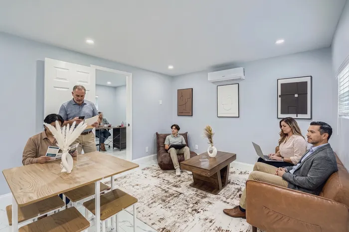 Modern meeting room with sleek decor, featuring a cozy seating area, elegant wooden table, and tasteful wall art, perfect for productive discussions.