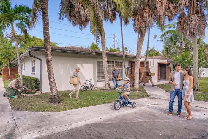 Charming suburban home with a lush garden, surrounded by palm trees and a welcoming community atmosphere.