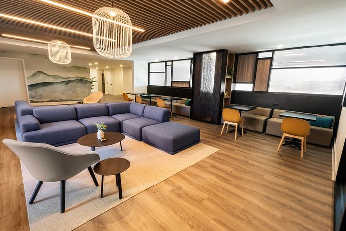 Elegant open-concept living space with modern design, featuring a cozy sectional sofa, stylish pendant lights, and warm wooden flooring.