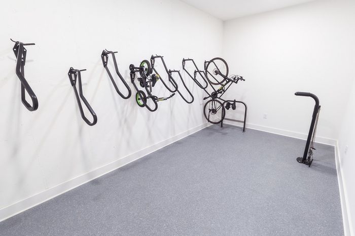 Modern bike storage room with sleek wall-mounted racks, featuring ample space and a minimalist design.