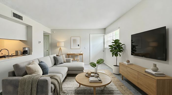 Elegant living room with a cozy sectional sofa, sleek coffee table, modern TV setup, and abundant natural light.