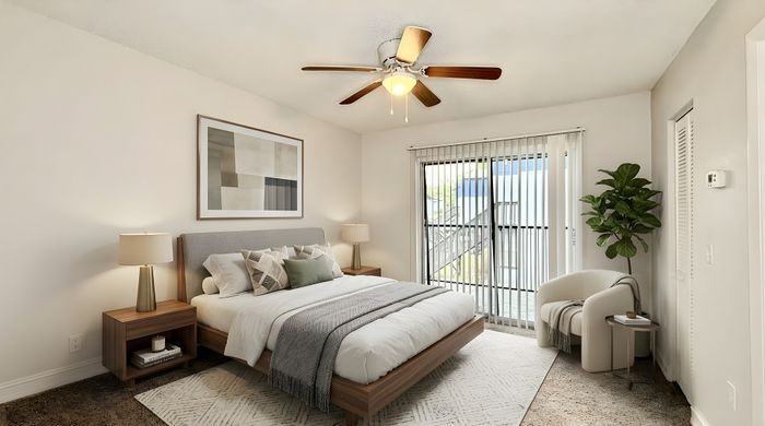 Elegant bedroom with a plush king-size bed, modern decor, and abundant natural light from large sliding glass doors leading to an outdoor view.