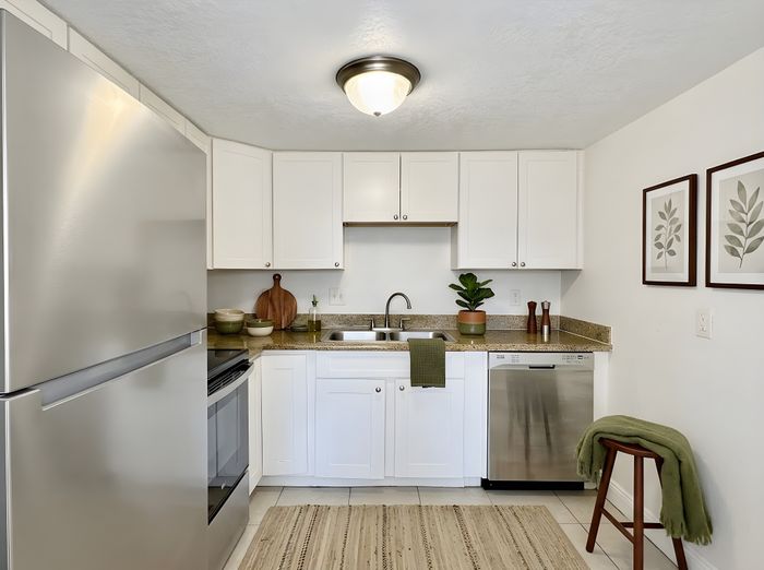 Chic modern kitchen with stainless steel appliances, white cabinets, and elegant decor accents.