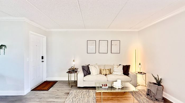 Chic living room boasting a cozy sofa with plush cushions, ambient lighting, and elegant decor in a modern apartment.