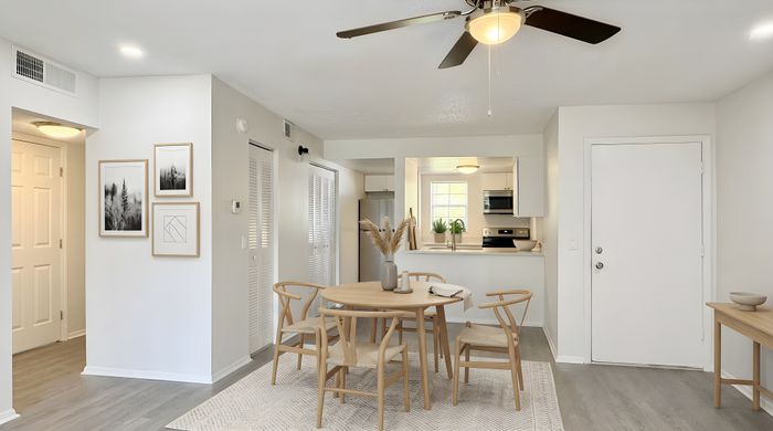 Charming dining area with elegant wooden furniture, accented by stylish decor and modern lighting, connected to an inviting open-plan kitchen.
