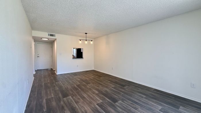 Modern apartment interior with sleek laminate flooring, bright lighting, and a cozy open space.