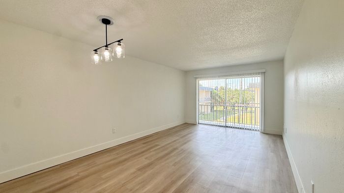 Bright and airy living space with elegant lighting and large windows opening to a scenic view, perfect for modern living.