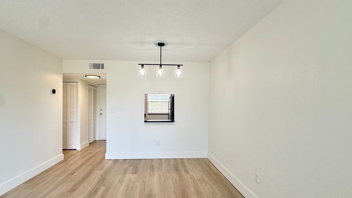 Modern apartment interior featuring sleek hardwood floors, clean white walls, and stylish ceiling lighting.