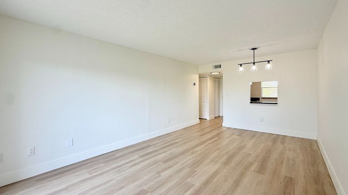 Bright and airy living space with modern wooden flooring and stylish overhead lighting, perfect for a contemporary lifestyle.