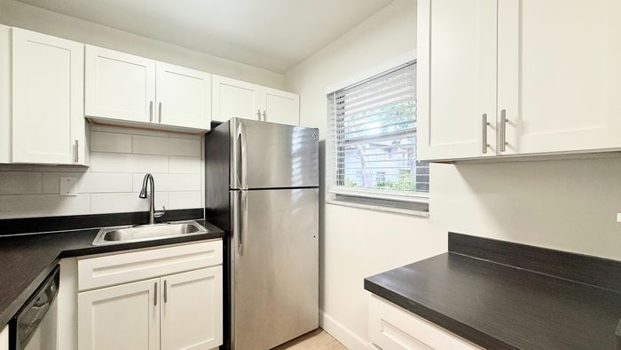 Bright and modern kitchen with sleek stainless steel appliances, elegant white cabinetry, and ample natural light.