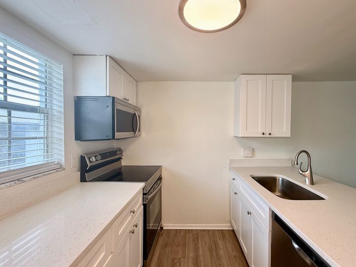 Modern kitchen with sleek countertops, stainless steel appliances, and ample natural light.