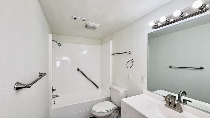 Modern bathroom with sleek fixtures, bright lighting, and a pristine white bathtub for a fresh and inviting atmosphere.