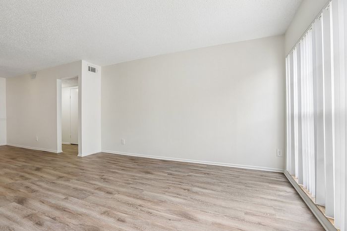 Bright and airy interior with elegant wood flooring and large vertical windows, offering a modern and inviting atmosphere.